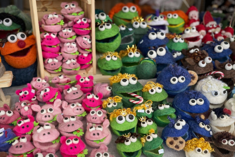 Verschiedene farbige Plüschfiguren in Tierformen, darunter Frösche und Schweine.